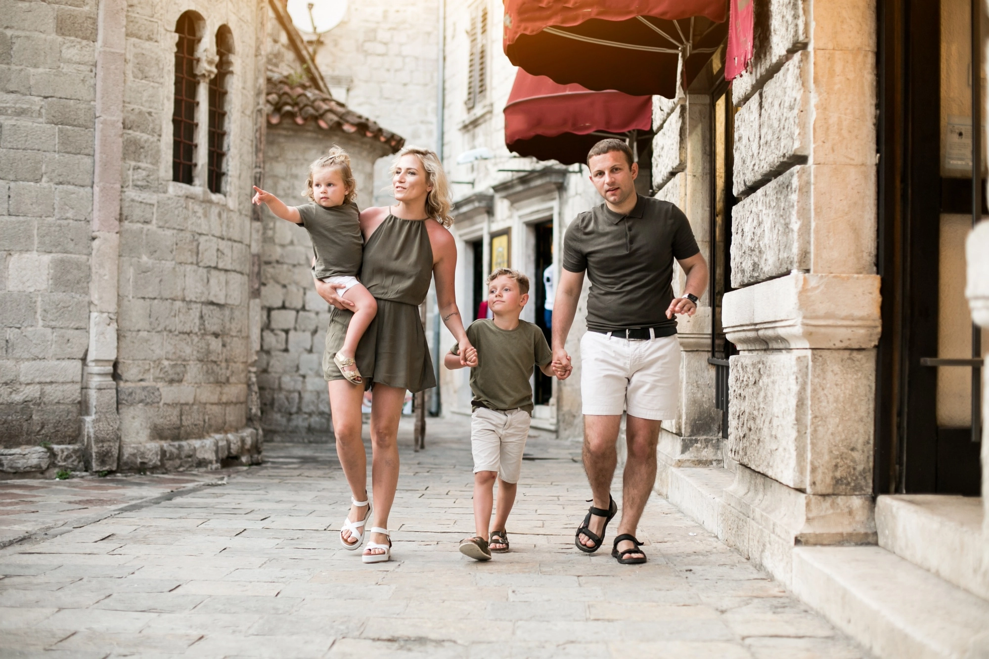 Famiglia in visita tra le vie di un borgo storico vicino a Venezia, esperienza family friendly raggiungibile dal Titian Inn Hotel Venice Airport